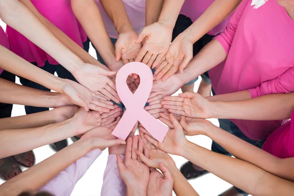 Ruban rose tenu entre deux mains pour symboliser le soutien